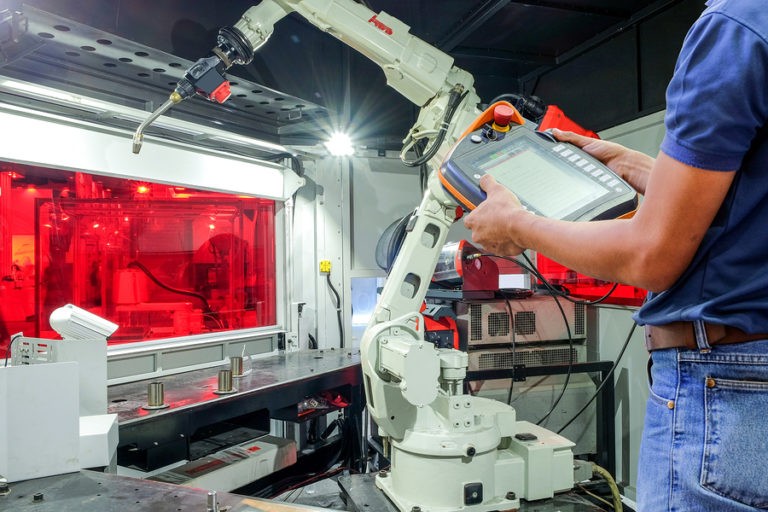 Engineers use a wireless remote control of robotic welding for smart factory, industry 4.0 concept