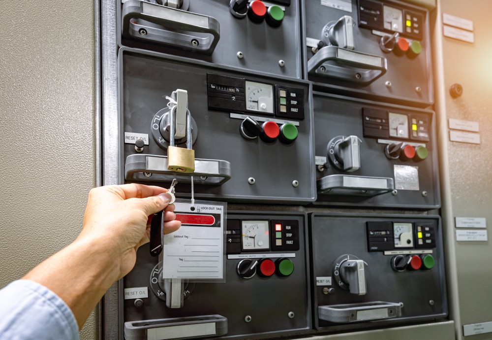 Worker unlocking the lock on startup switch for power source
