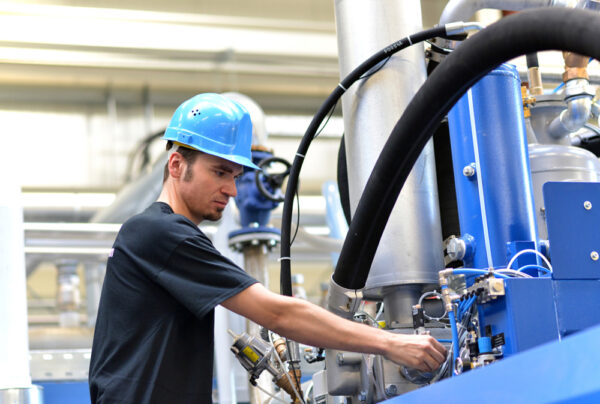 Operator Repairs A Machine In An Industrial Plant With Tools