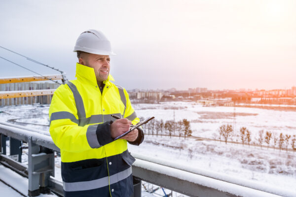 A Smiling Caucasian Builder In A White Hard Hat