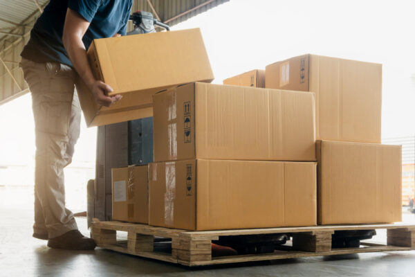 Worker Courier Lifting Package Boxes Stacking On Pallet. Supply Chain.