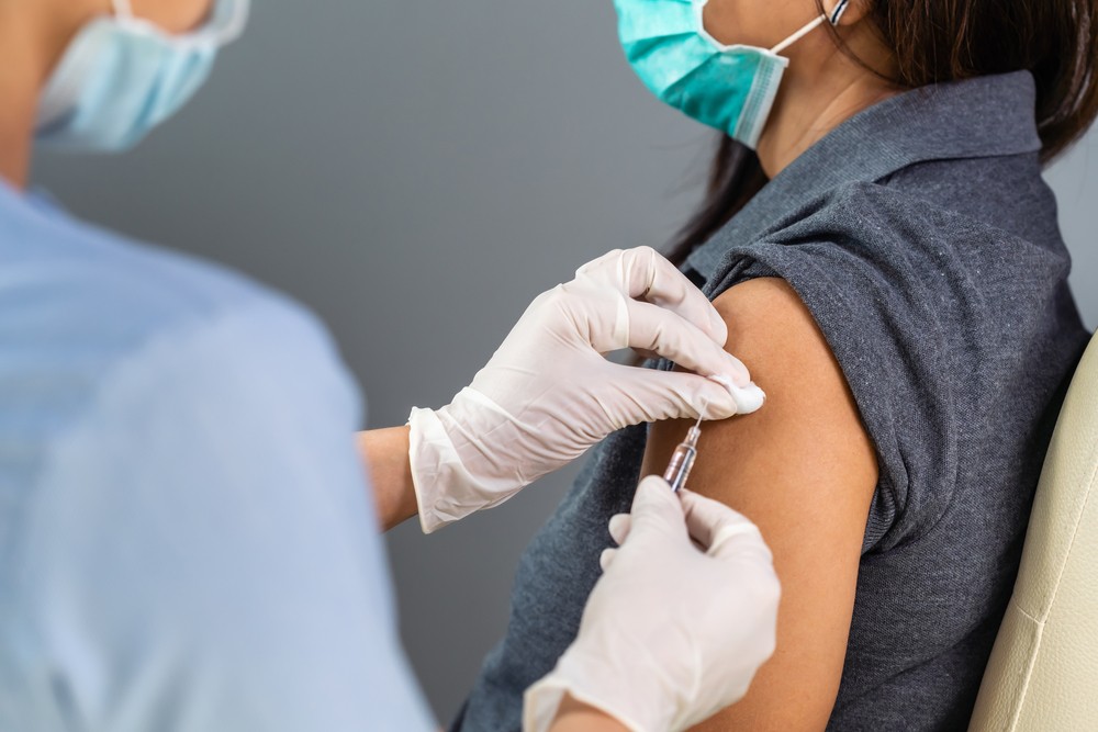 A woman receiving a vaccine from a doctor