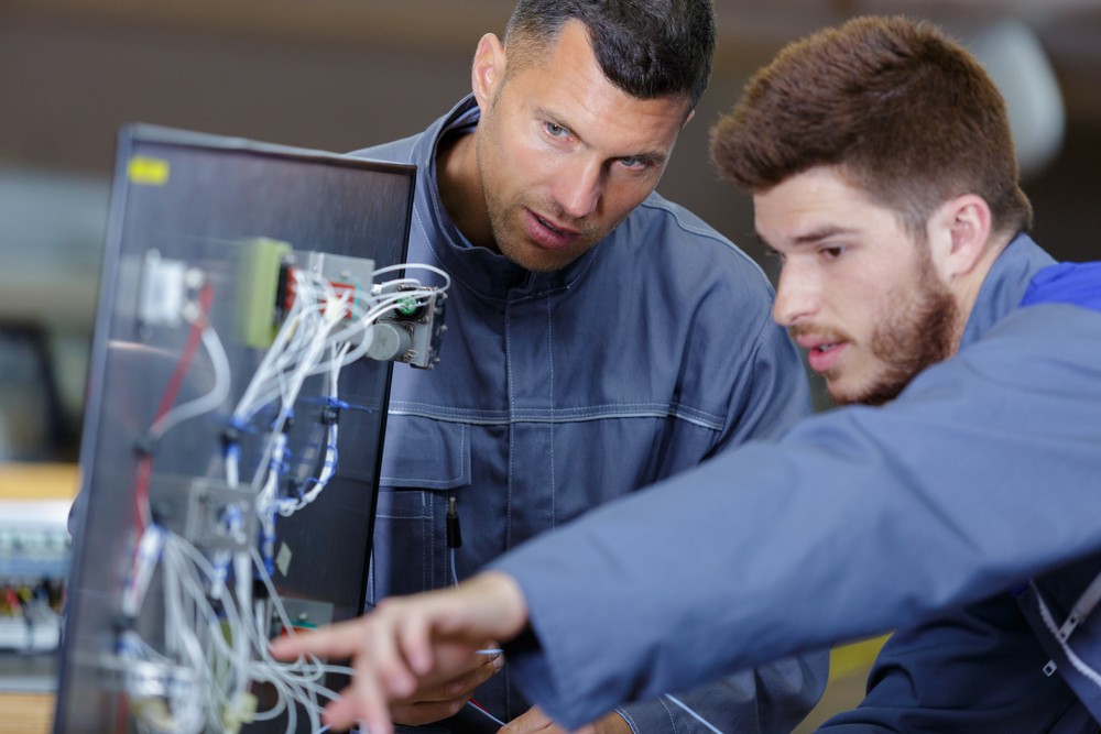 Two men diagnosing and troubleshooting equipment failure