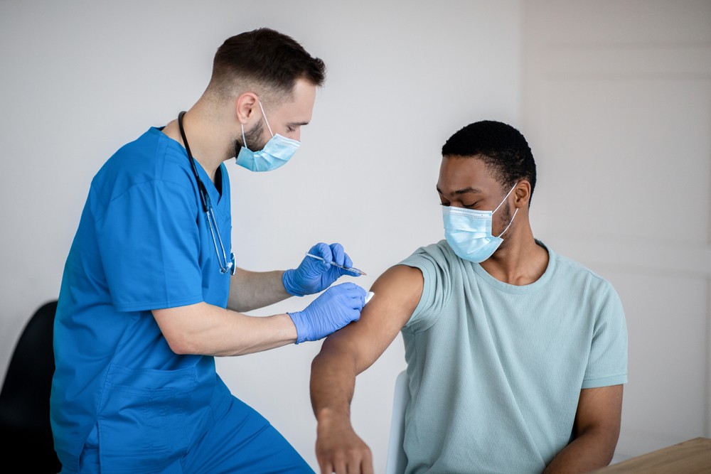 A nurse giving a man a vaccine 