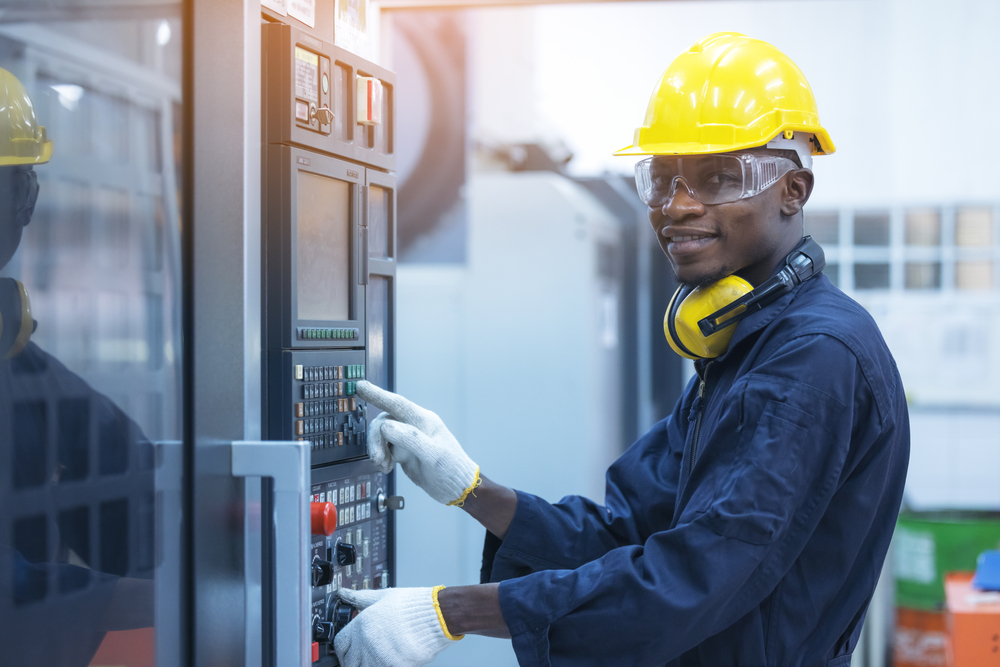 Man Working At Programmable Machine In Factory