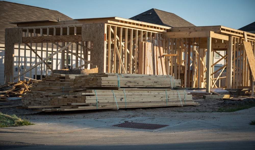 Lumber supplies sitting outside of a house in construction
