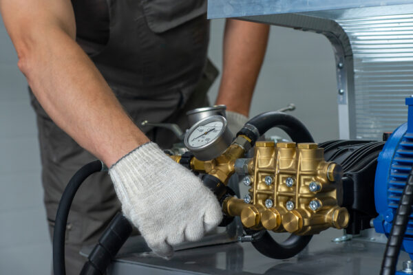 A Man's Hand In A White Glove Turns On A Valve