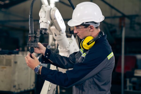 Young Factory Worker Working With Adept Robotic Arm