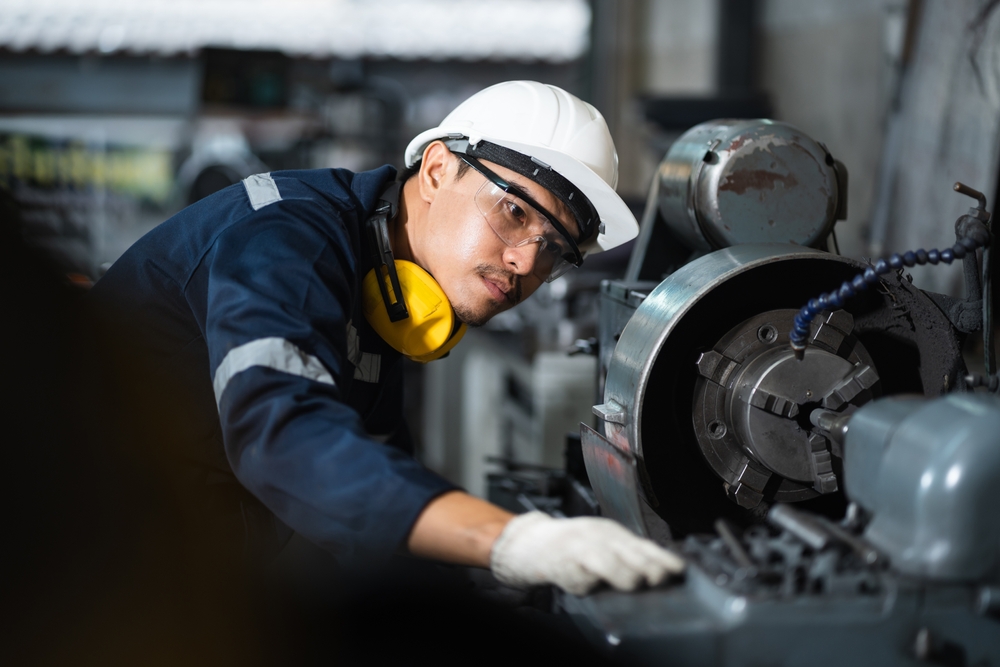 Engineer Mechanical In Safety Suit Working With Grinding Machine
