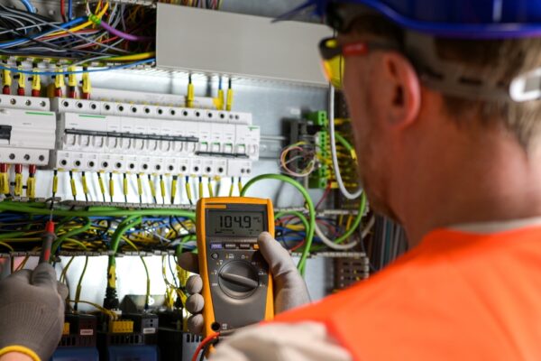 Electrician In Blue Helmet Yellow Glasses And Orange Vest
