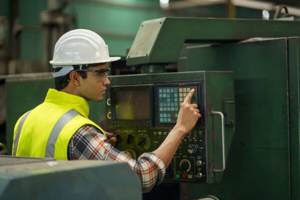 Industrial Worker Controlling CNC Machine