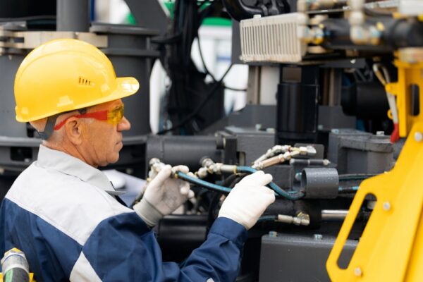 Worker Checks Piping System Of Hydraulic Hose Valves