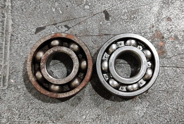 A Close-up Of A Used and new Ball Bearing