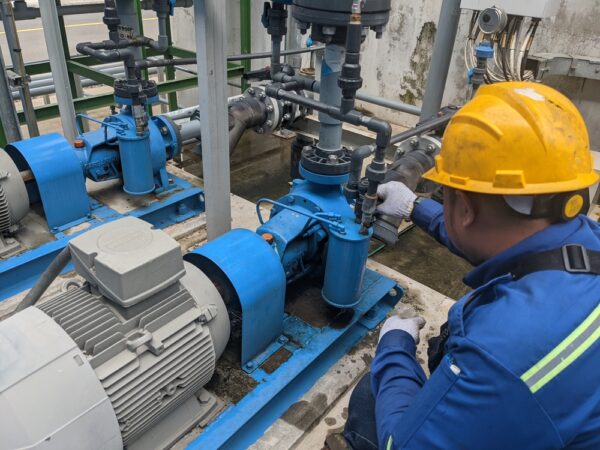 A Technician Is Inspecting An Industrial Pump