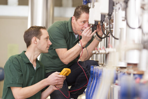 Senior technician and junior technician repairing agriculture machinery