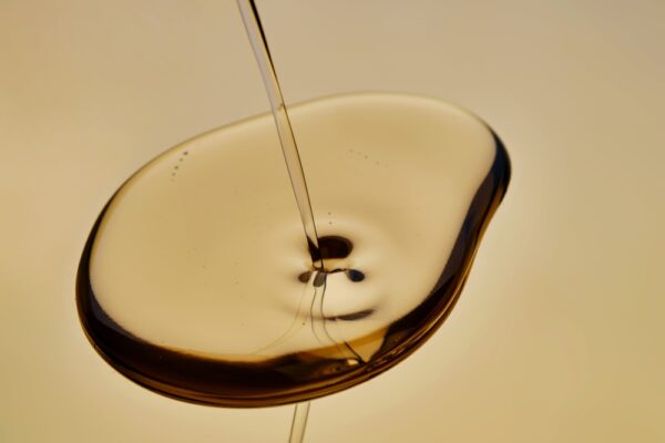 Pouring Hydraulic Oil On A Golden Background.