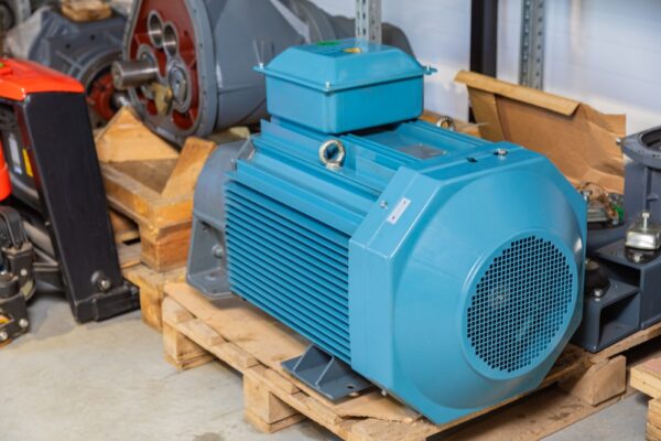Large Blue Electric Motor Sits On A Wooden Pallet