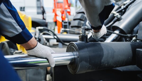Worker Mechanic Checks Pipe System Of Hydraulic Hose