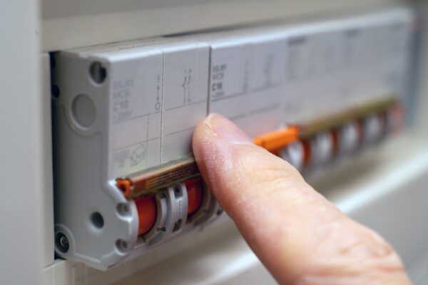 A Detailed Close-up Shows A Finger Engaging A Circuit Breaker