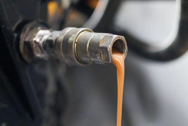 Close Up Of Milky Brown Contaminated Hydraulic Oil Draining From