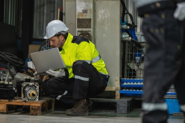 Industrial Engineers Holding Laptop Inspecting Servo Motor