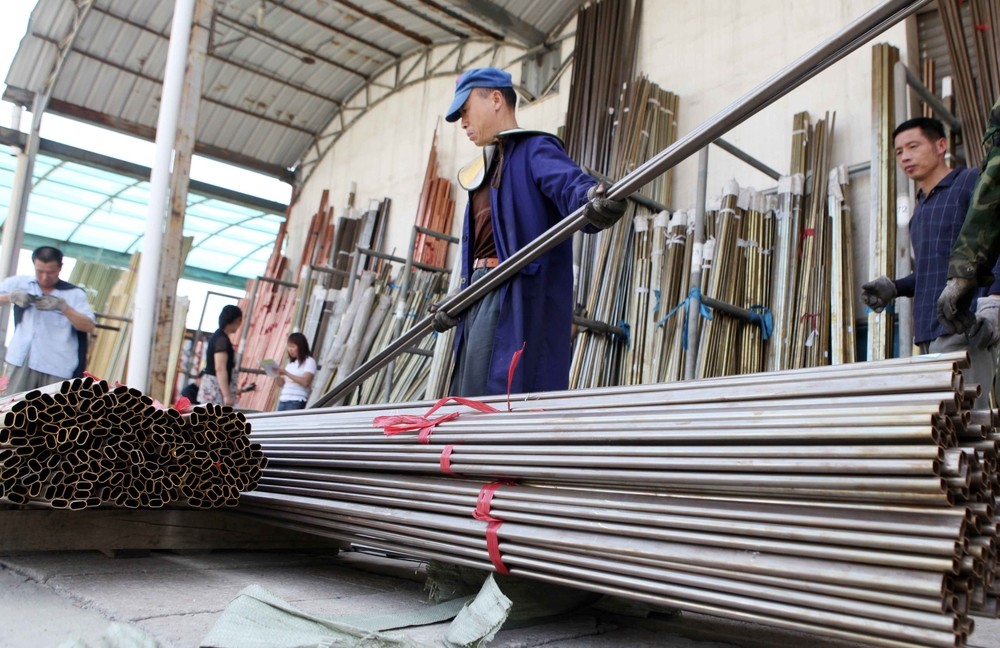 Engineers moving metal rods in a warehouse